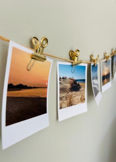 Flera foton upphängda med klipp på en snöre mot en ljus vägg.